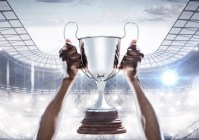 Hands holding a champion trophy in stadium