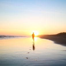 silhouette-of-boy-running-in-body-of-water-during-sunset-694587